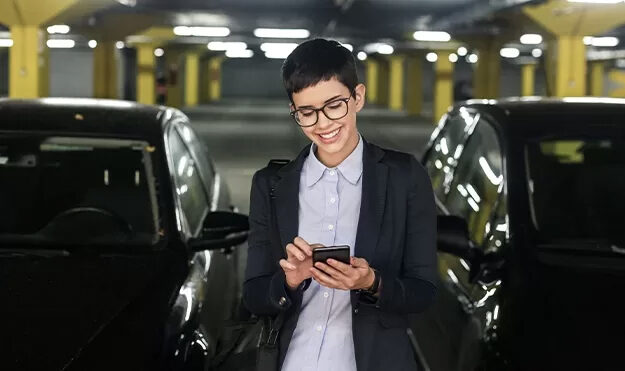 Woman using smart phone in a parking garage
