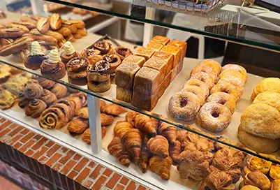 variety of pasties behind a pastry case.